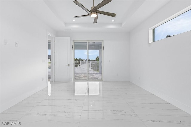 empty room with recessed lighting, a raised ceiling, marble finish floor, and ceiling fan