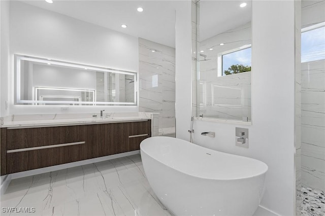 bathroom featuring marble finish floor, recessed lighting, a marble finish shower, a soaking tub, and vanity