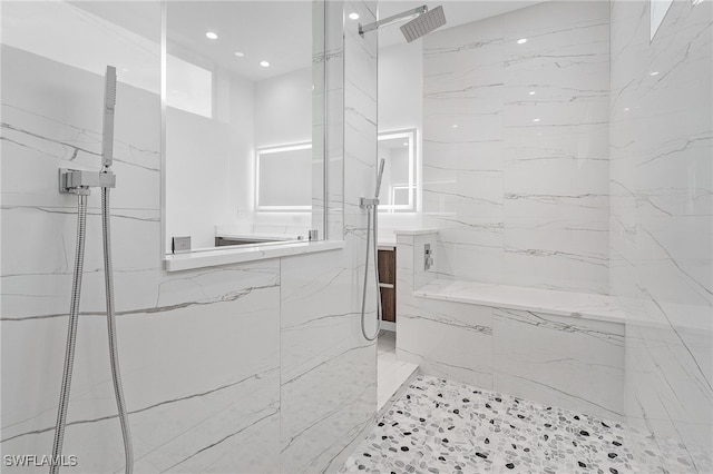 bathroom featuring tiled shower and vanity