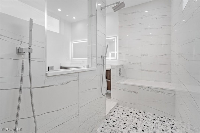 full bath featuring a marble finish shower and tile walls