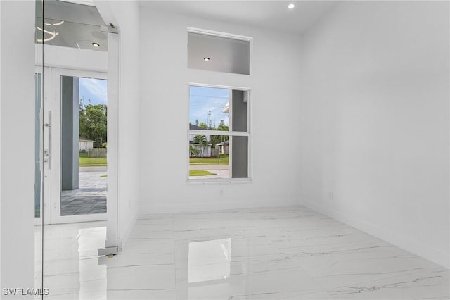 unfurnished room featuring baseboards and marble finish floor