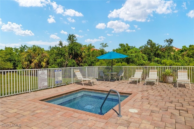 view of swimming pool with fence, a community hot tub, and a patio