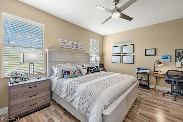 bedroom featuring a ceiling fan, light wood-style flooring, and baseboards