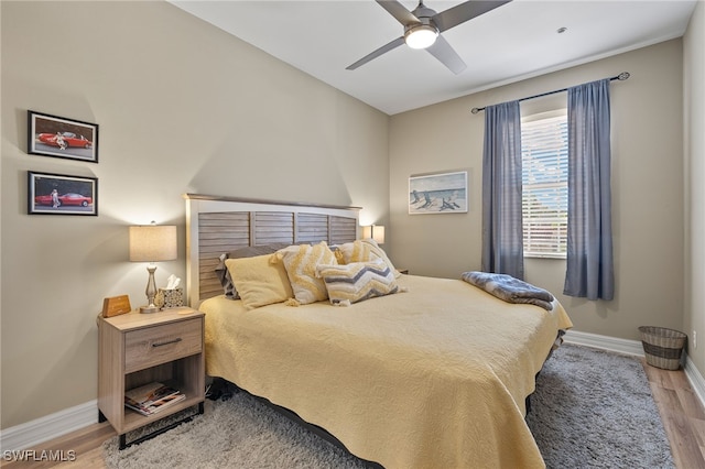 bedroom with ceiling fan, baseboards, and wood finished floors