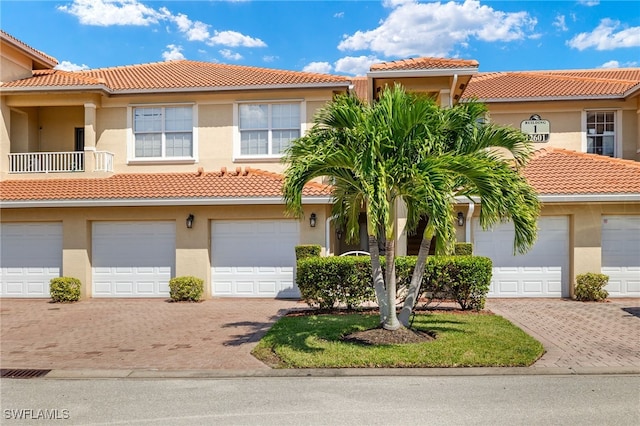 view of front of property featuring driveway, a tile roof, and stucco siding