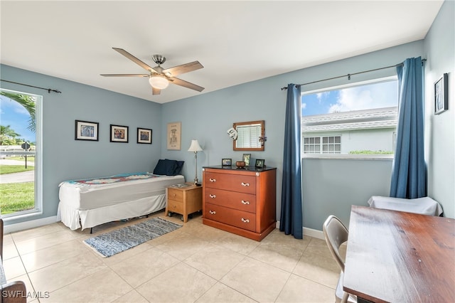 bedroom featuring ceiling fan, light tile patterned flooring, and multiple windows