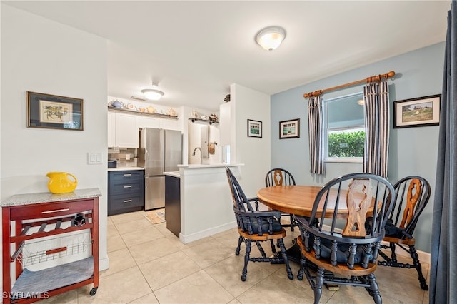 dining space with light tile patterned floors and sink