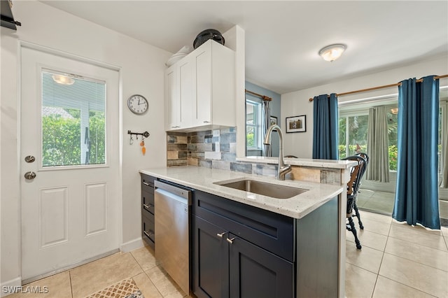 kitchen with light stone counters, dishwasher, sink, white cabinetry, and decorative backsplash