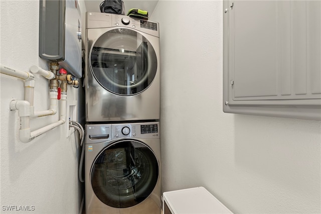 laundry room featuring electric panel and stacked washing maching and dryer