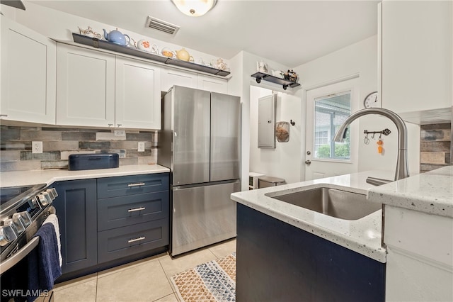 kitchen with light stone counters, appliances with stainless steel finishes, decorative backsplash, and white cabinetry