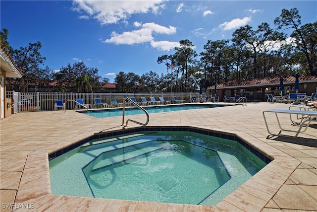 view of swimming pool with a hot tub and a patio area