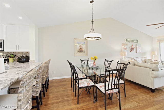 dining space with light hardwood / wood-style floors and lofted ceiling