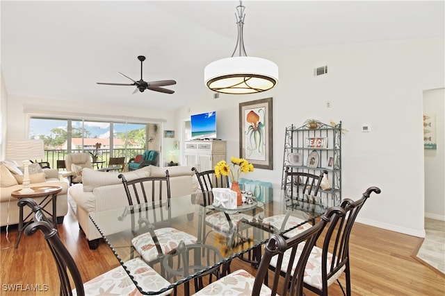 dining area with light wood-type flooring, lofted ceiling, and ceiling fan