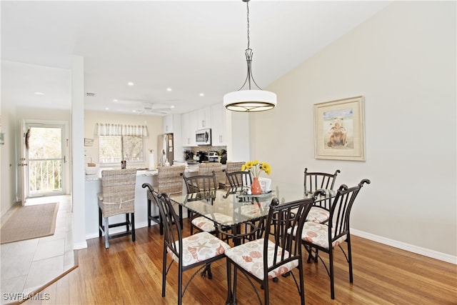 dining area with vaulted ceiling, light hardwood / wood-style floors, and ceiling fan