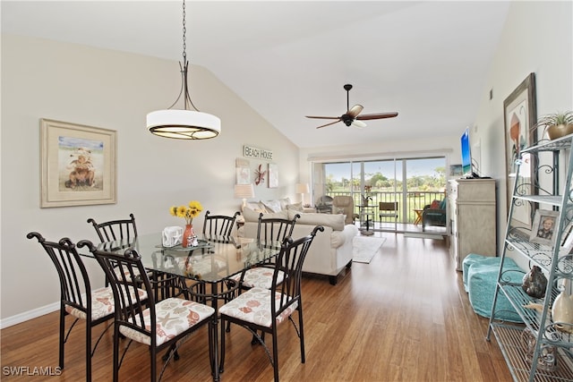 dining area with hardwood / wood-style floors, ceiling fan, and high vaulted ceiling