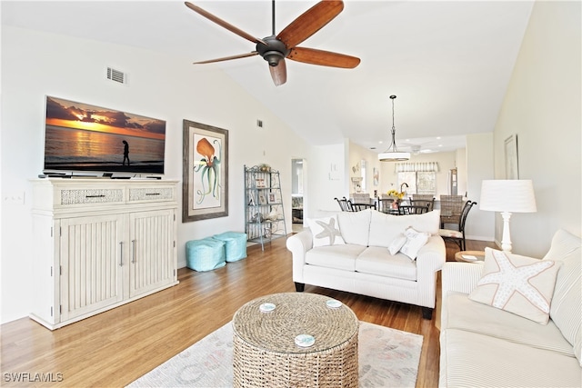 living room with lofted ceiling, ceiling fan, and hardwood / wood-style floors