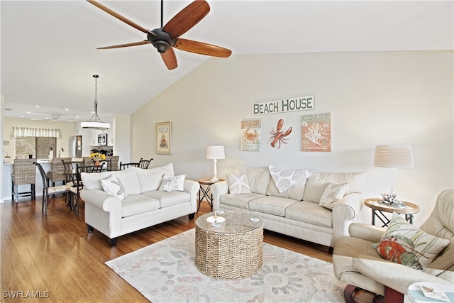 living room with vaulted ceiling, hardwood / wood-style floors, and ceiling fan