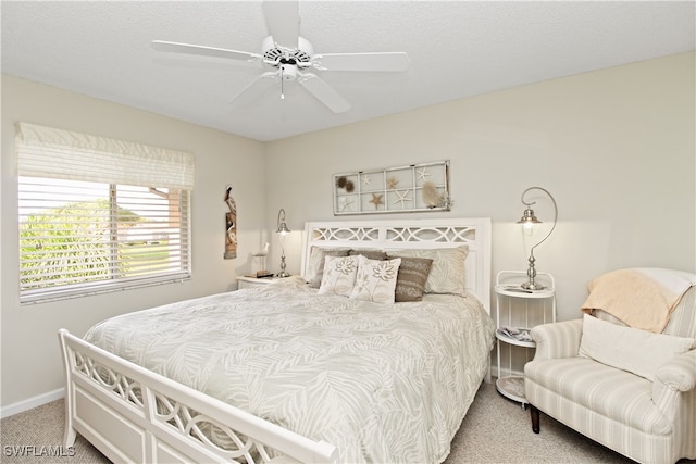 carpeted bedroom with ceiling fan and a textured ceiling