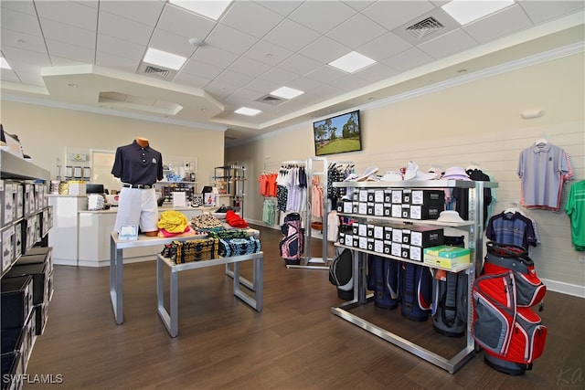 workout area with a paneled ceiling, ornamental molding, and dark hardwood / wood-style flooring