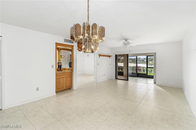 empty room featuring ceiling fan with notable chandelier and light tile patterned floors