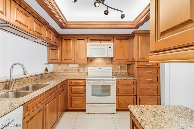 kitchen with white appliances, light stone counters, and sink