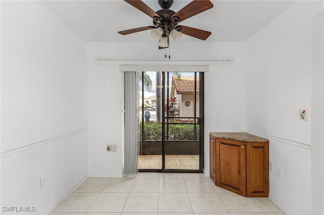 unfurnished room with ceiling fan and light tile patterned flooring