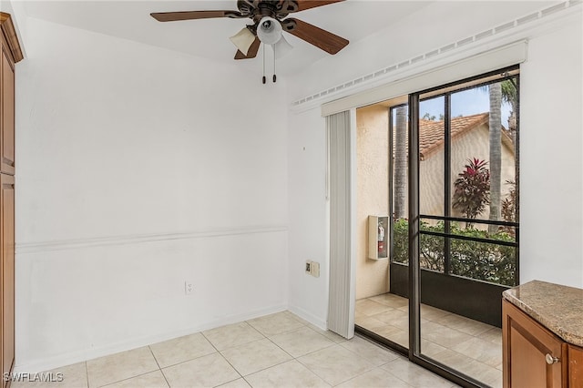 unfurnished room with ceiling fan and light tile patterned flooring