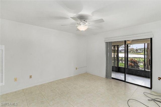 empty room with ceiling fan and light tile patterned floors