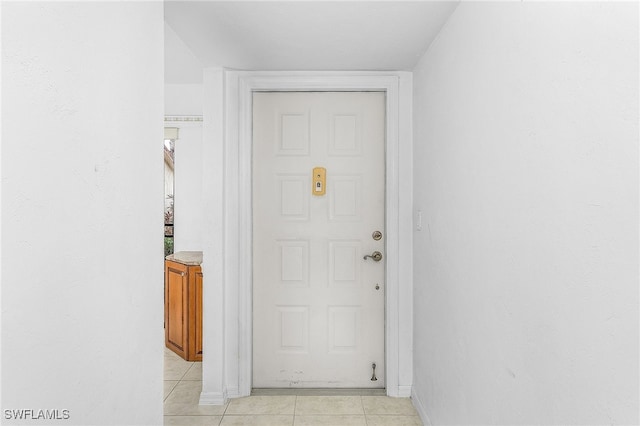 doorway to outside with light tile patterned floors