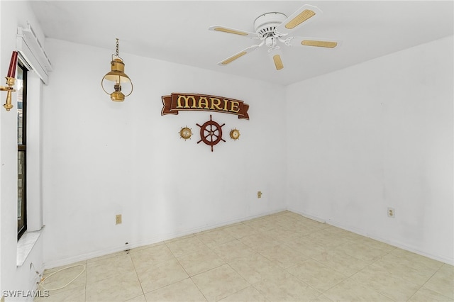 tiled empty room featuring ceiling fan and a healthy amount of sunlight