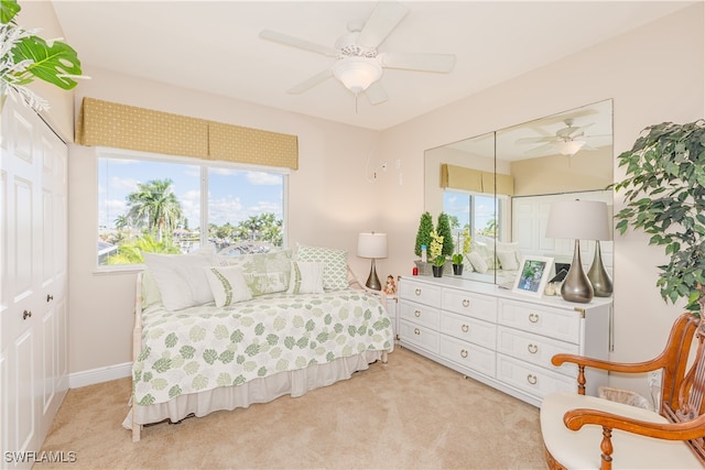 carpeted bedroom with ceiling fan and a closet