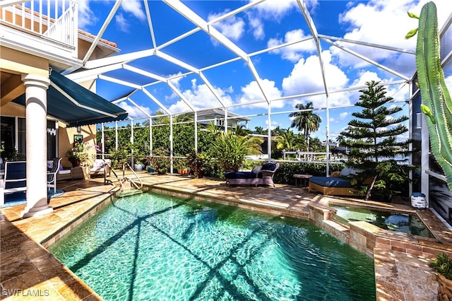 view of swimming pool featuring a lanai, an in ground hot tub, and a patio