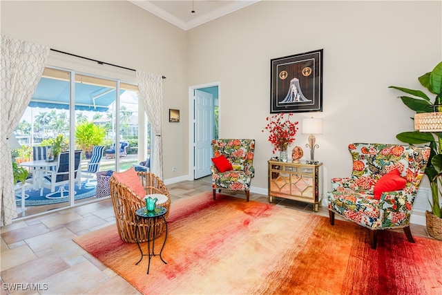 sitting room with a high ceiling and crown molding