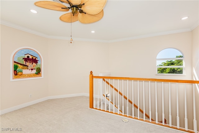 carpeted spare room featuring ceiling fan and ornamental molding