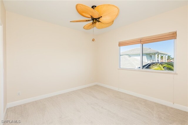 empty room featuring ceiling fan and light colored carpet