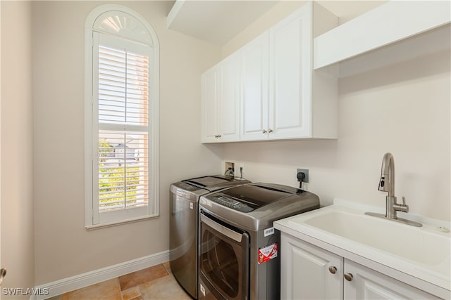 washroom featuring washer and dryer, sink, and cabinets