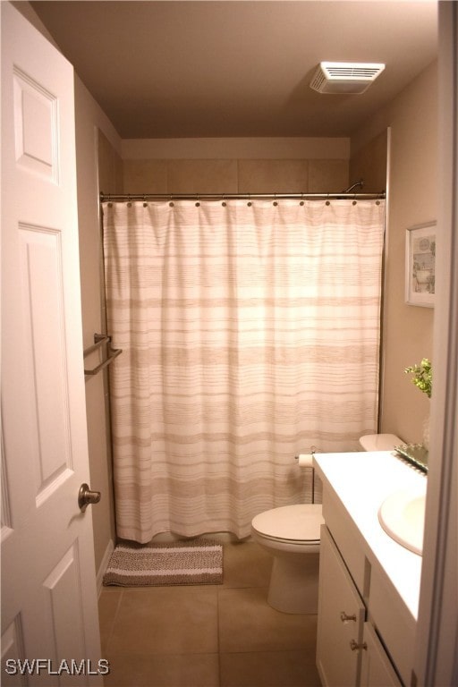 bathroom featuring a shower with shower curtain, vanity, toilet, and tile patterned floors