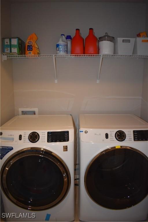 clothes washing area featuring washing machine and clothes dryer and laundry area