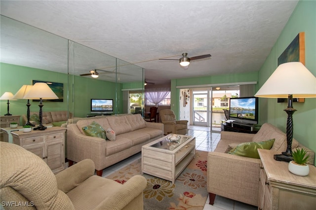 living room with a textured ceiling, light tile patterned floors, and ceiling fan