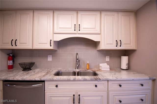 kitchen with backsplash, stainless steel dishwasher, white cabinetry, and sink