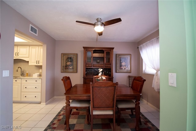 dining space featuring ceiling fan, light tile patterned floors, and sink