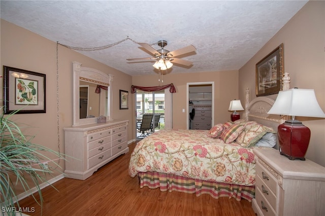 bedroom featuring ceiling fan, a textured ceiling, light hardwood / wood-style flooring, and a closet