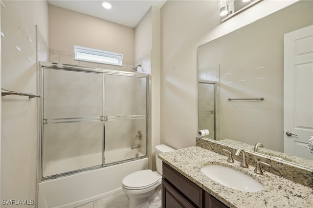 full bathroom featuring combined bath / shower with glass door, tile patterned floors, vanity, and toilet