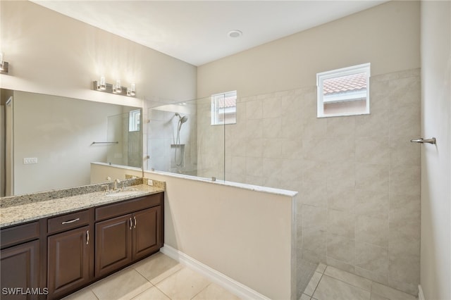 bathroom featuring vanity, tile patterned flooring, and tiled shower