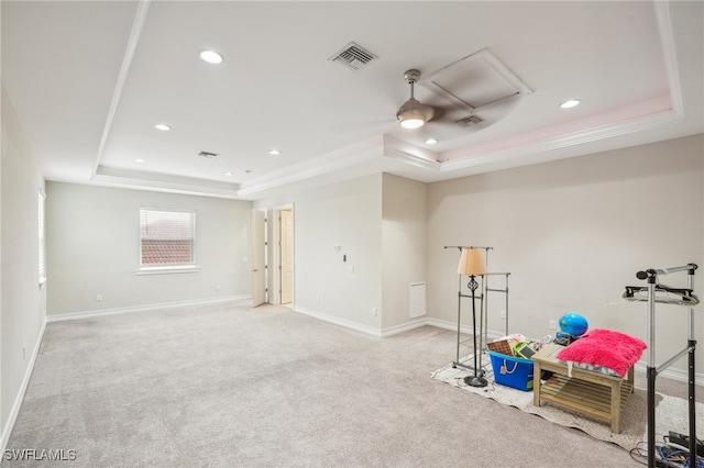 interior space with light colored carpet, ceiling fan, and a raised ceiling