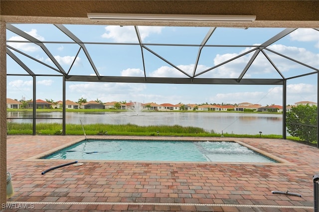 view of swimming pool with a lanai, a water view, and a patio area