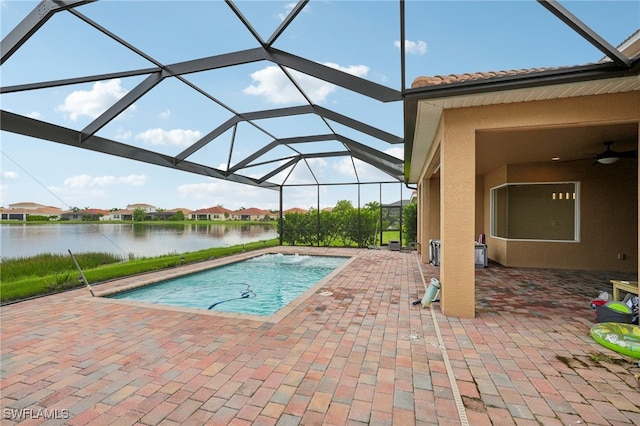 view of swimming pool with a water view, glass enclosure, and a patio