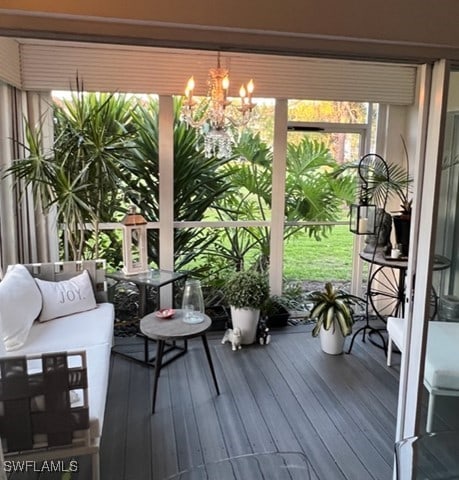 sunroom / solarium featuring a chandelier