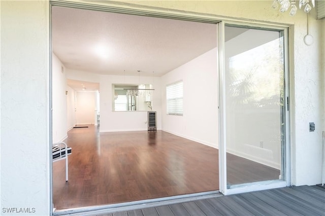 interior space with baseboards, wine cooler, and wood finished floors