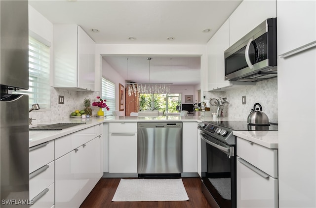 kitchen featuring decorative backsplash, light countertops, white cabinets, appliances with stainless steel finishes, and dark wood-type flooring